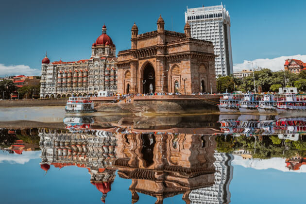 Das monumentale Gateway of India in Mumbai bei Sonnenuntergang, mit vielen Besuchern auf dem Vorplatz. | Gebeco