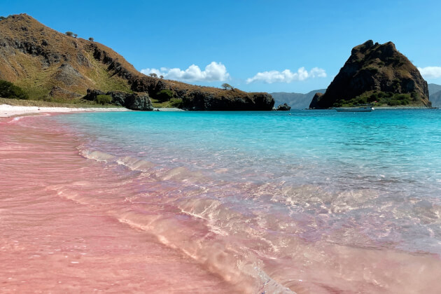 Rosa Sandstrand am Pink Beach auf der Insel Komodo in Indonesien mit türkisblauem Meer und Felsformationen. | Gebeco