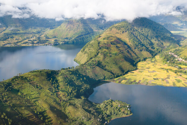 Panoramablick auf den Tobasee auf Sumatra, umgeben von grünen Hügeln und Dörfern. | Gebeco