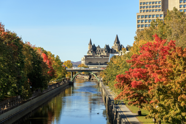 Herbstliche Bäume am Rideau Canal in Ottawa mit Blick auf das Château Laurier, Kanada