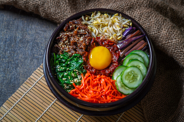 Traditionelles koreanisches Bibimbap in einer Schüssel mit bunten Zutaten. | Gebeco