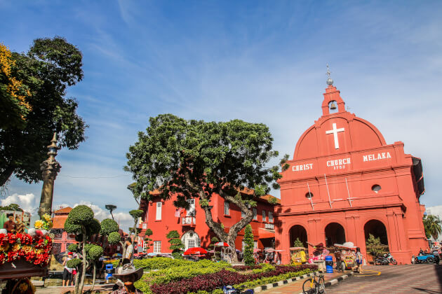 Frontansicht der roten Christ Church in Melaka mit belebter Straße im Vordergrund. | Gebeco