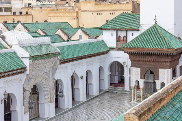 Innenhof einer historischen Madrasa in Fès Marokko mit Mosaiken und grünen Ziegeldächern. | Gebeco