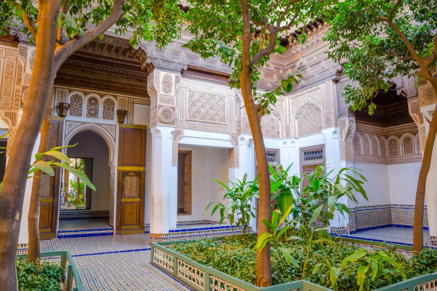 Traditioneller Innenhof in Marrakesch Marokko mit verzierten Bögen und Garten. | Gebeco
