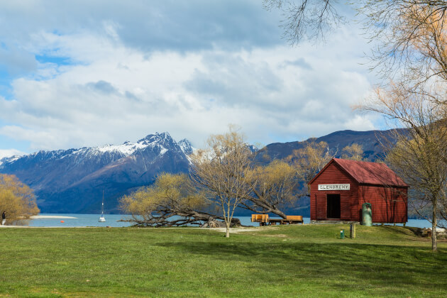 Historisches rotes Bootshaus in Glenorchy am Lake Wakatipu, umgeben von Bergen in Neuseeland. | Gebeco