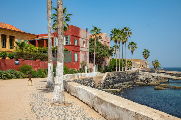 Bunte Kolonialhäuser und Palmen an der Küste der Insel Gorée bei Dakar, Senegal. | Gebeco