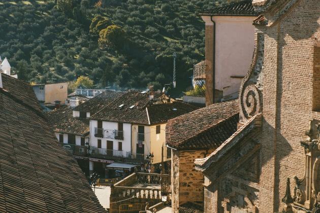 Historische Altstadt in Extremadura mit verwinkelten Gassen, Ziegeldächern und Hügelkulisse im Abendlicht. | Gebeco