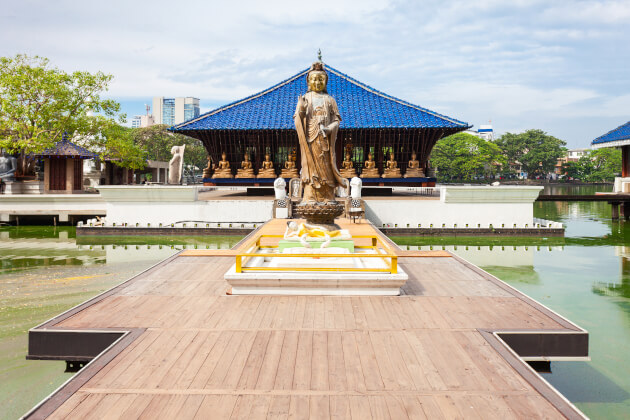 Gangaramaya Tempel in Sri Lanka Im Zentrum eine Statue umgeben von WasserI Gebeco