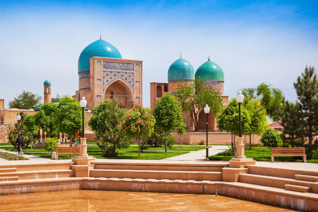 Kok Gumbaz Moschee mit türkisfarbenen Kuppeln in Shahrisabz, Usbekistan, umgeben von Parkanlage. | Gebeco
