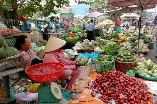 Straßenhändlerinnen mit traditionellen Hüten auf einem Markt in Ho-Chi-Minh-Stadt. | Gebeco