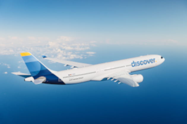 Langstreckenflugzeug von Discover Airlines im Flug über Wolken und blauem Himmel