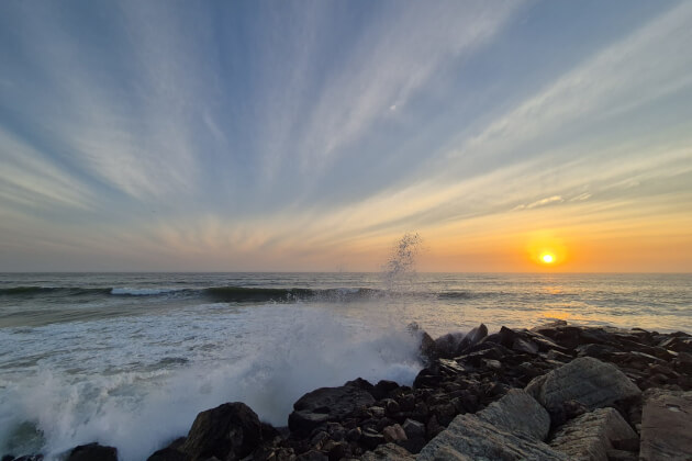 Bucht bei Lüderitz, Namibia — Wellen brechen an felsigem Ufer bei Sonnenuntergang über dem Atlantik
